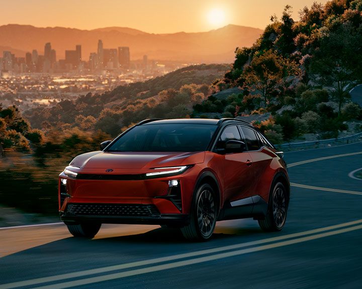 Overhead view of many cars in various colors, parked in three organized rows on a white background.