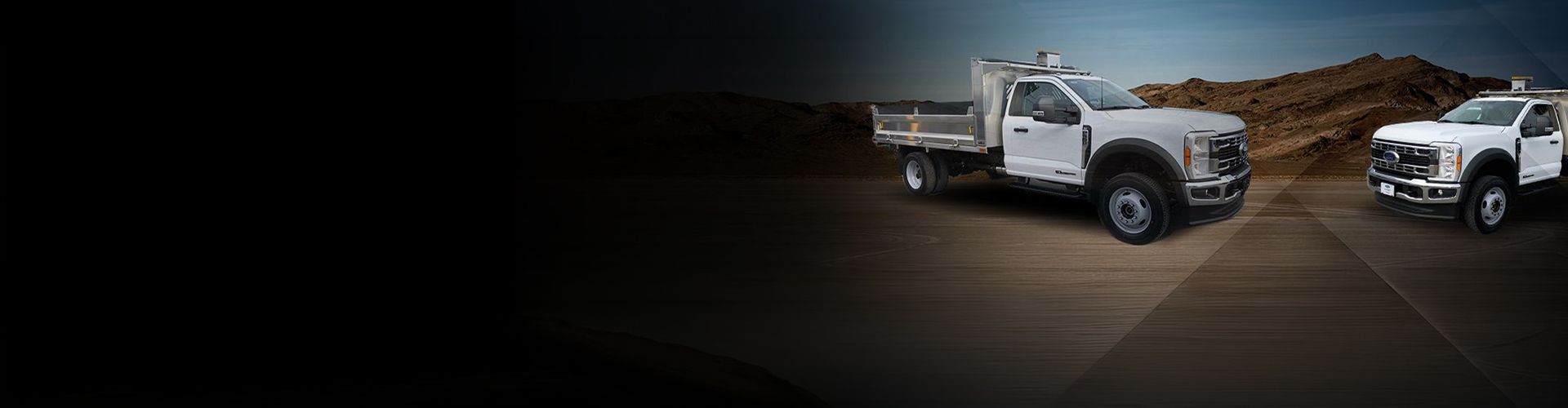 Promotional banner showing two white Ford Super Duty commercial trucks equipped with aluminum dump beds, set against a desert mountain background.