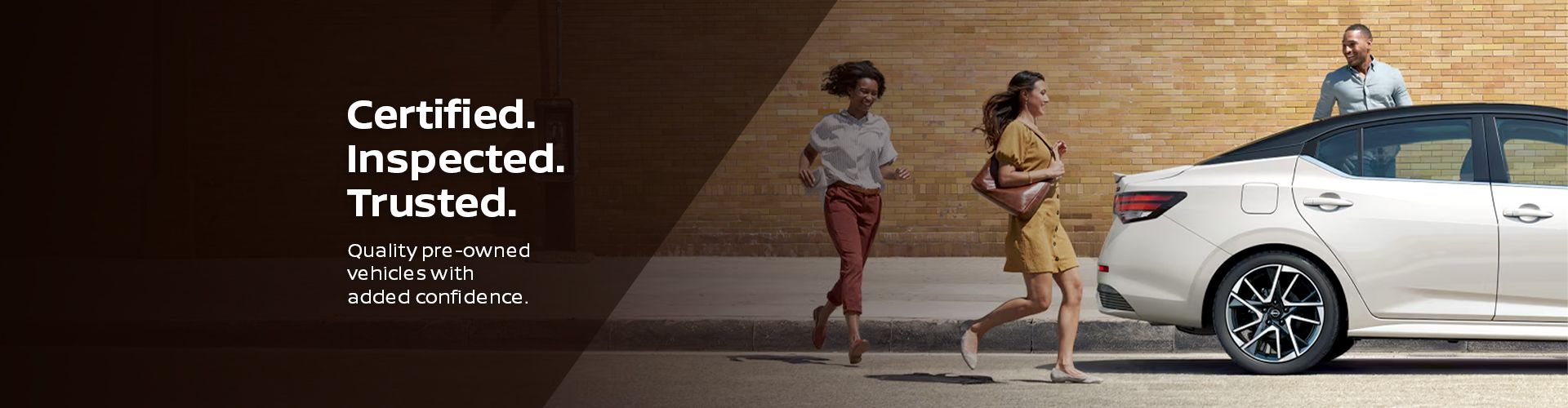 People happily walking near a parked white Nissan sedan.