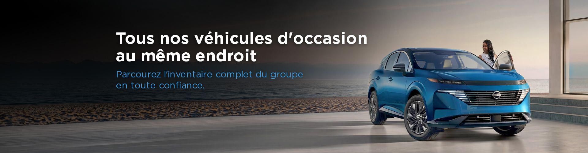 SUV Nissan bleu stationné en bord de mer avec une femme ouvrant la portière passager.