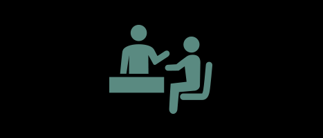 A sage-green minimalist icon on a black background showing two people at a desk, with one person appearing to provide service or information to a seated customer.