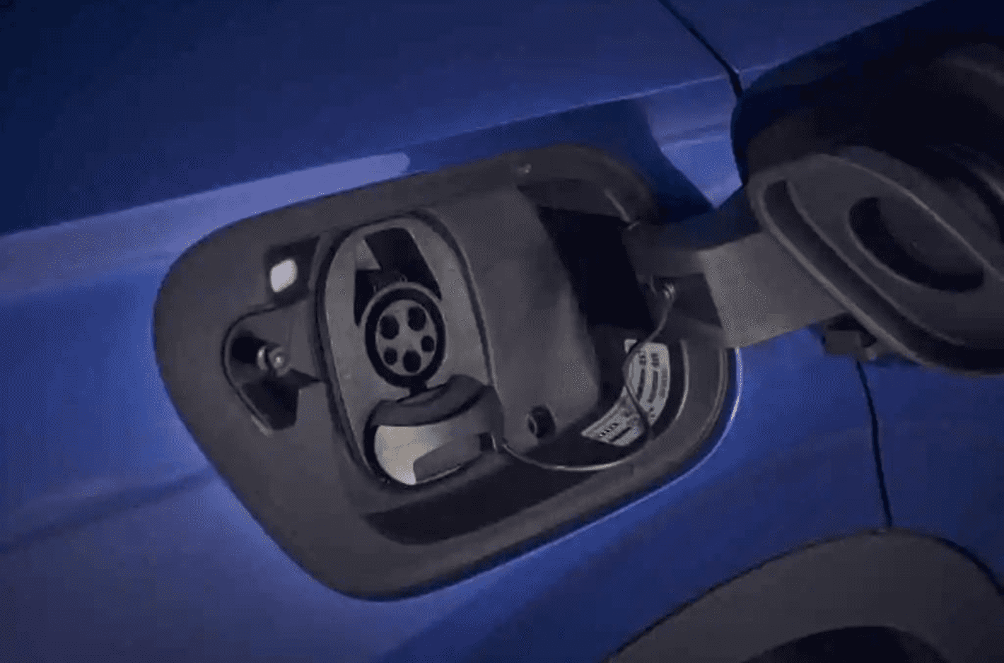 A close-up of the VW ID.4 open charging port, showing the CCS connector pins.