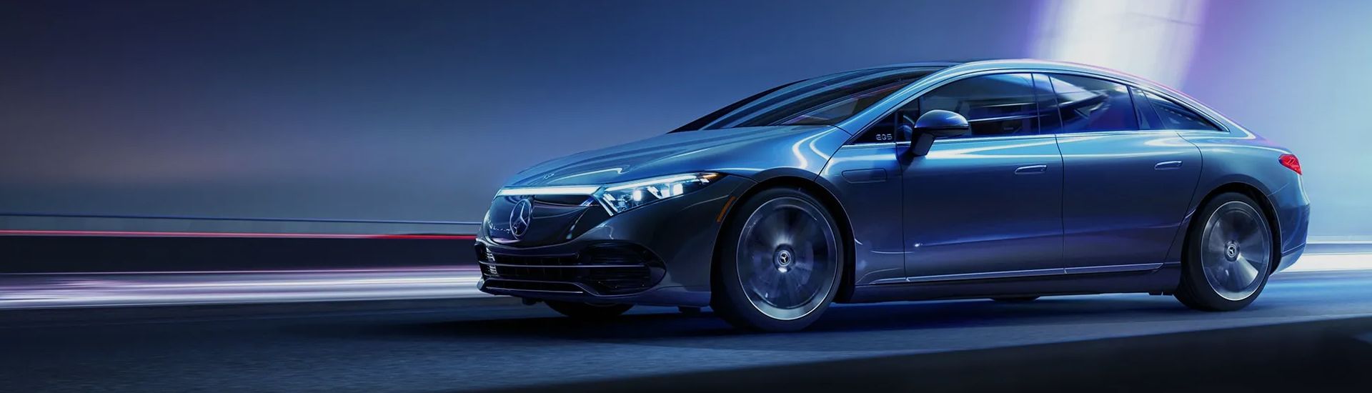 Blue Mercedes-Benz EQS driving at night with light trails