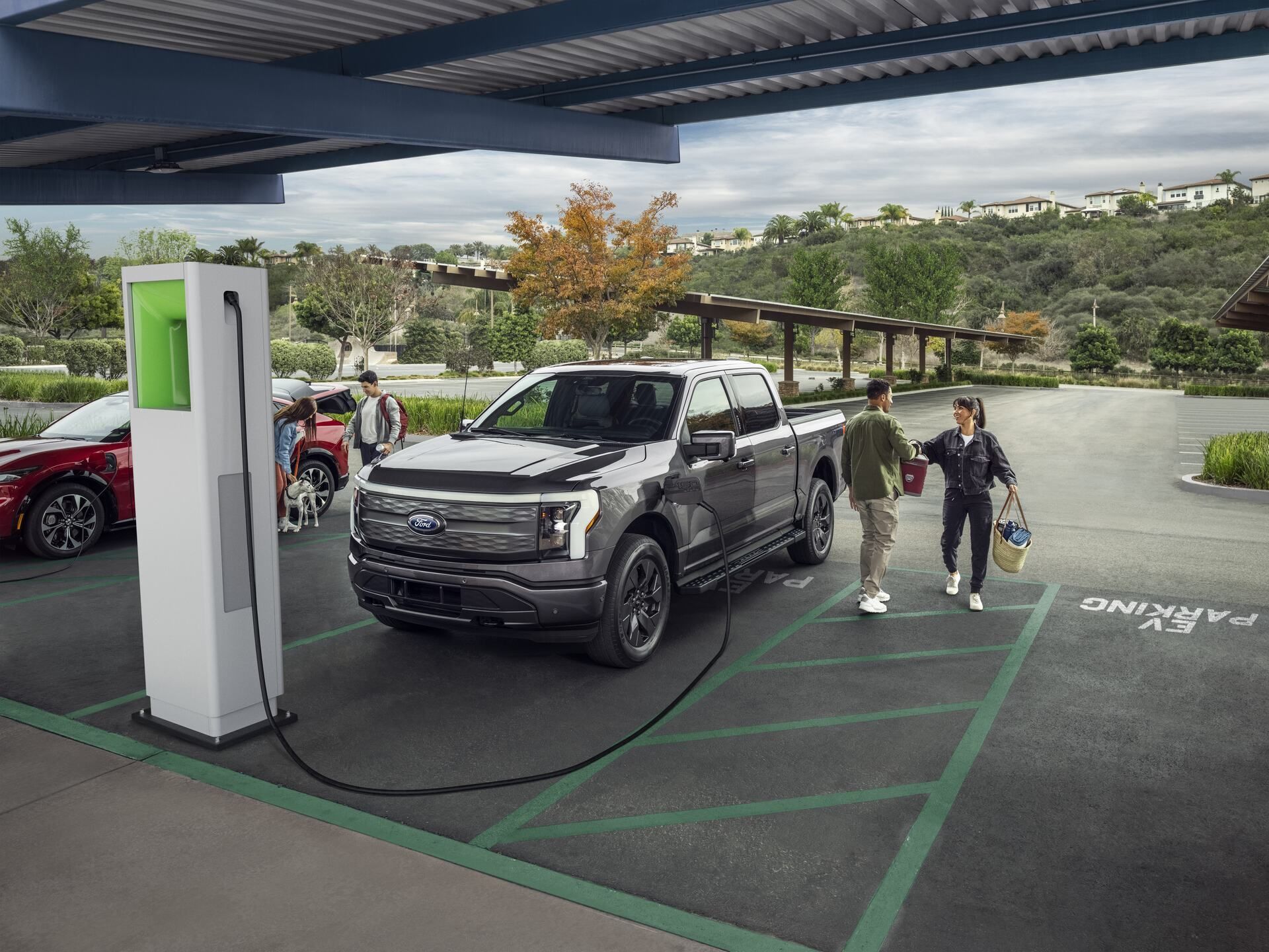 Couples at a public charging station charging a 2022 Mustang® Mach-E and F150 Lightning®