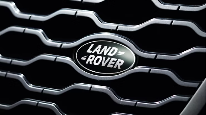 Close-up of the Land Rover logo on a vehicle's front grille, showing the green oval emblem with silver lettering.