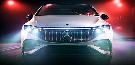 Front view of a white Mercedes-AMG EQE with headlights on