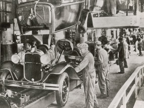 Photo historique en noir et blanc d'ouvriers sur une chaîne de montage automobile