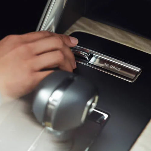 Driver’s toggling the Mi-drive switch in the CX-90's centre console.  