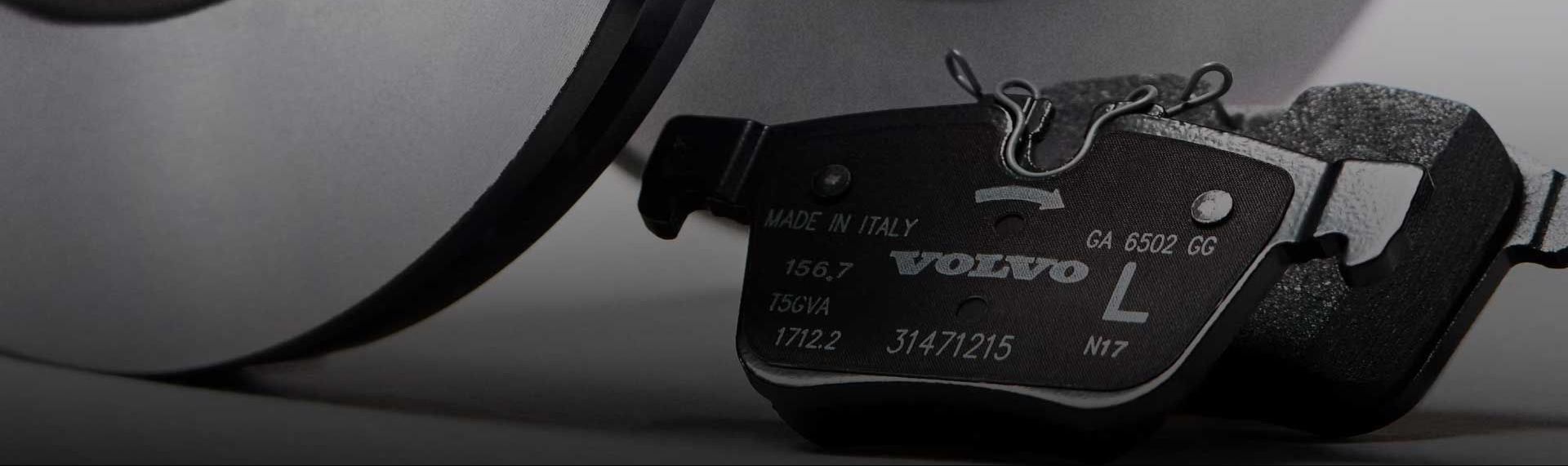A close-up of a Polestar high-performance brake caliper and a slotted disc rotor on a car.