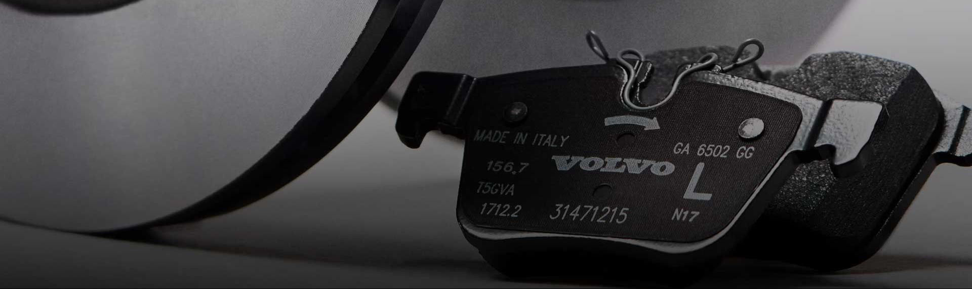 A close-up of a Polestar high-performance brake caliper and a slotted disc rotor on a car.