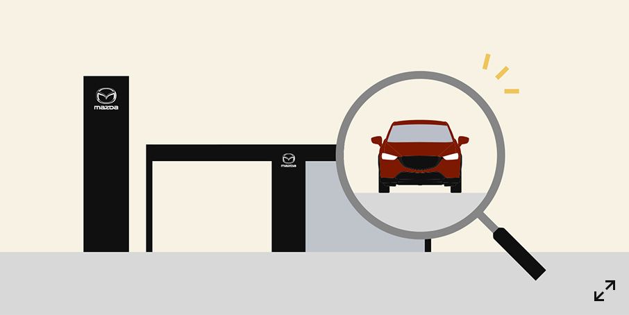 An illustration of a Mazda dealership entrance with a large magnifying glass focused on a red car, symbolizing the search and inspection process when choosing a new vehicle.