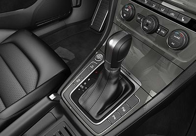 Gros plan du levier de vitesse automatique et de la console centrale d'une Volkswagen, montrant l'intérieur en cuir.