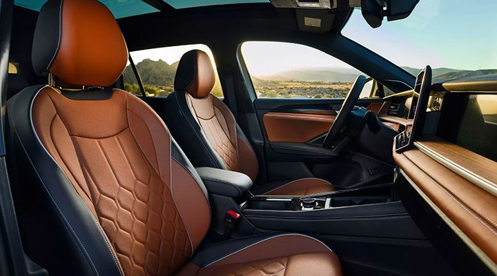 Interior view of the vehicle's front seats and dashboard, featuring brown and black leather seating and a panoramic sunroof.