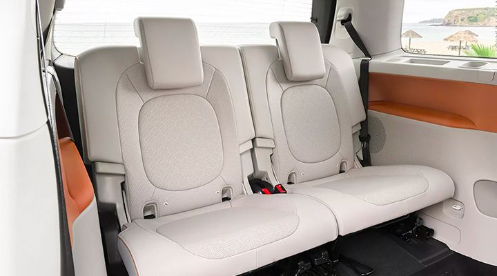 Close-up view of the rear seats (third row) of a van with light beige upholstery.