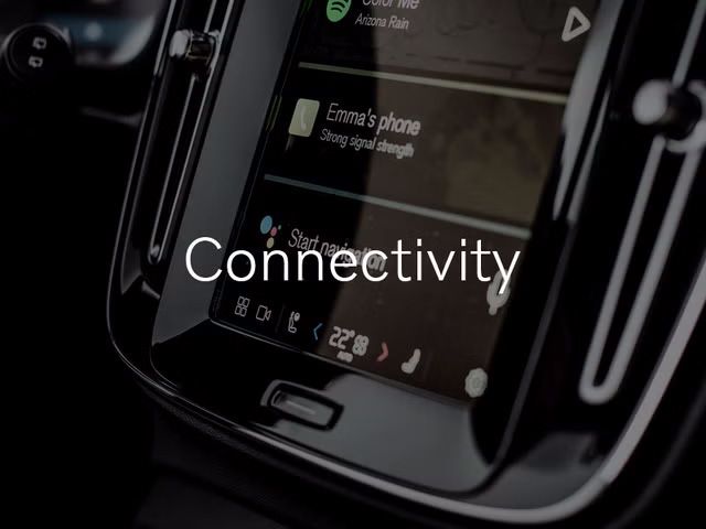  A close-up of the infotainment touchscreen in a Volvo, showing options for phone connectivity and media. The word "Connectivity" is overlaid on the image.