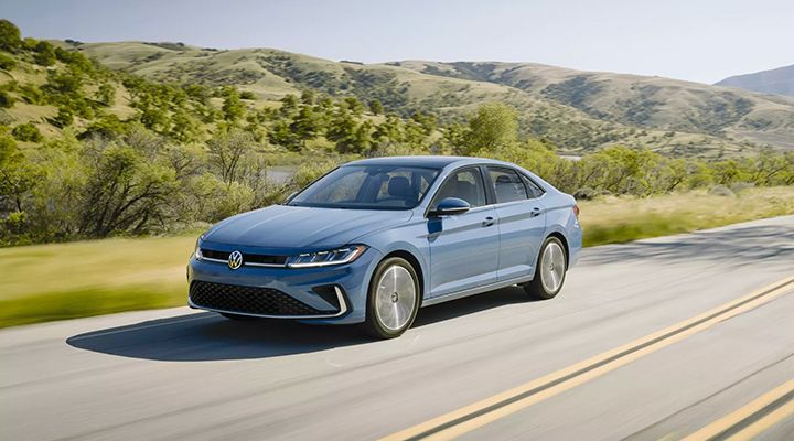 Side view of the 2026 Volkswagen Jetta in blue parked on a scenic road.