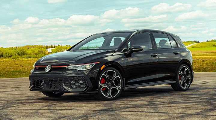 Front three-quarter view of a black Volkswagen Golf GTI, showing the headlight design, the grille, and the red brake calipers.