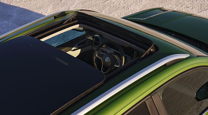 Top view of the 2026 Volkswagen Taos with its panoramic sunroof open, revealing the front seats and steering wheel.