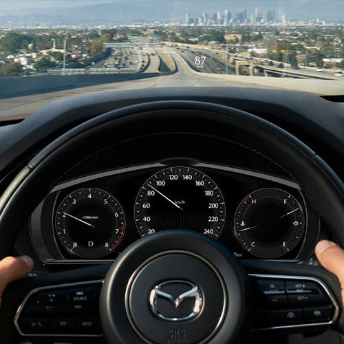 Drivers POV of hands on steering wheel inside a moving vehicle.  
