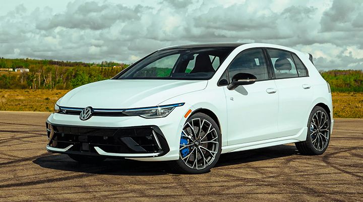 Three-quarter front view of a white Volkswagen Golf R with blue brake calipers, parked outdoors.