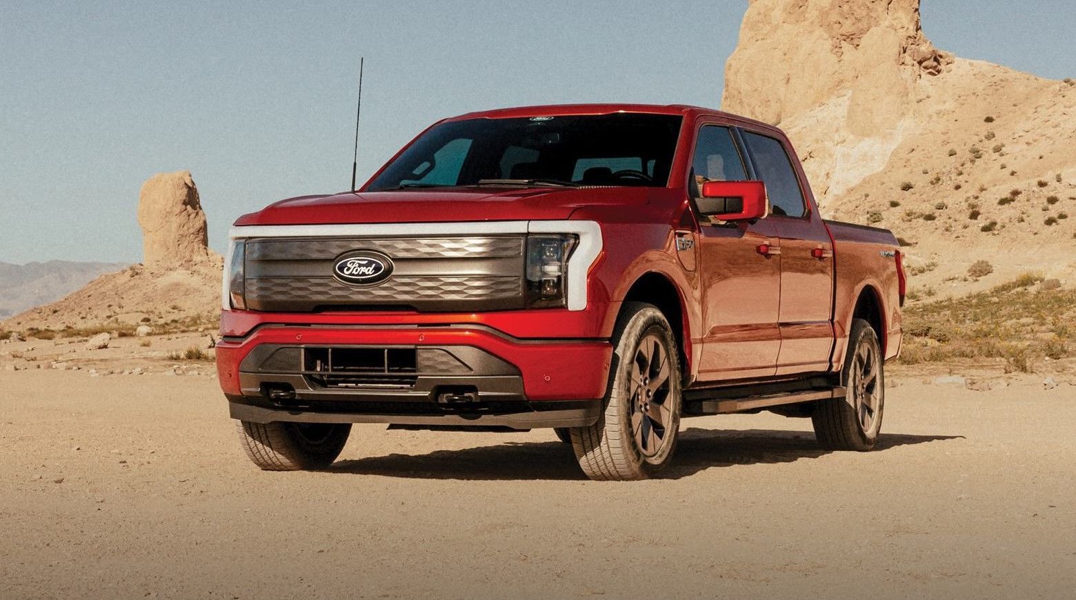 2024 F150 Lightning parked in front of a desert mountain.