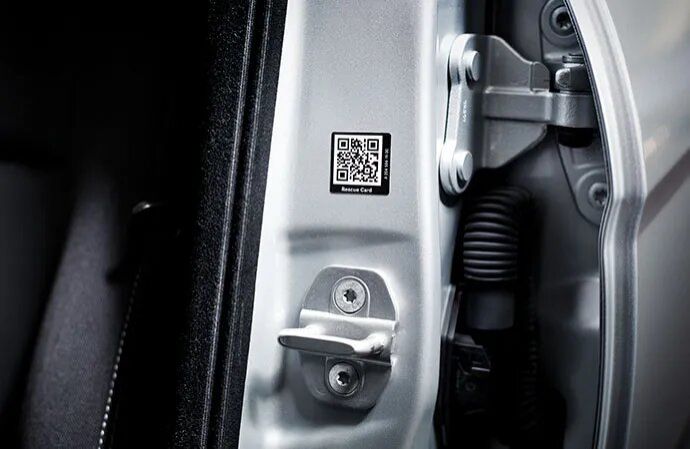 Close-up of a rescue card QR code sticker on a car door pillar.