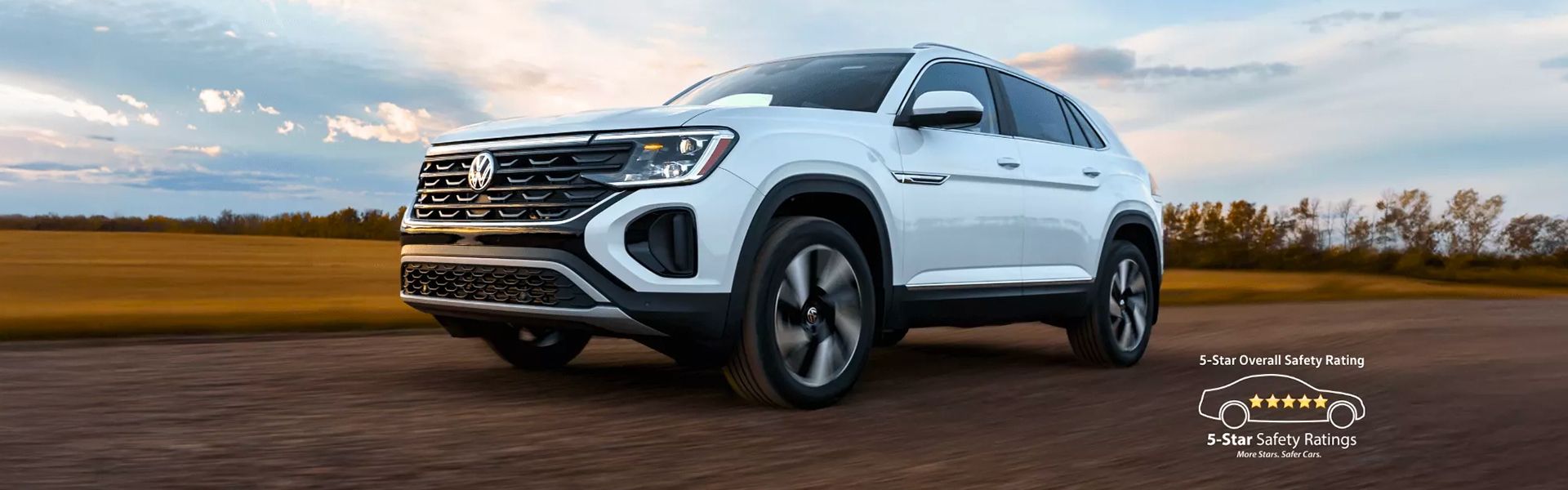 Un VUS Volkswagen Atlas noir roule sur une route dégagée au coucher du soleil. Un emblème de sécurité 5 étoiles est superposé dans le coin inférieur droit.