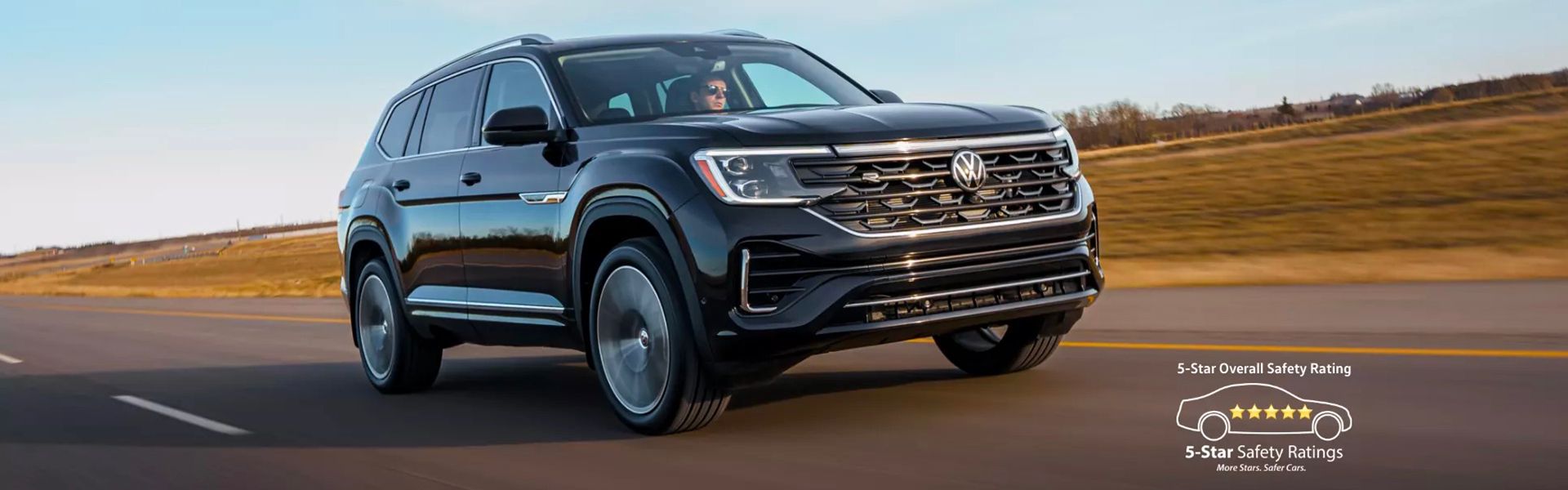 A black Volkswagen Atlas SUV drives on an open highway at sunset. A 5-Star safety rating emblem is overlaid in the bottom right corner.