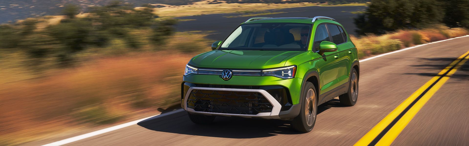 The 2026 Volkswagen Taos in green driving through scenic roads, with dynamic full-angle exterior shots. Promoted as Canada’s #1 German-engineered SUV.