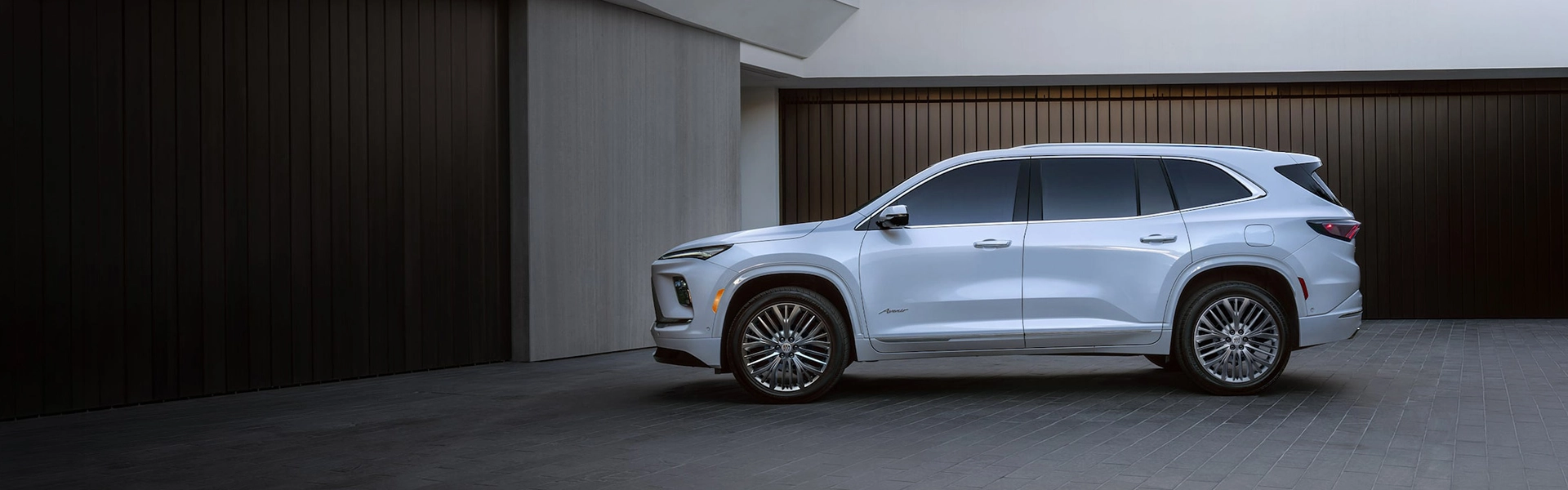 SUV Buick Enclave 2027 bleu stationné devant une maison moderne.