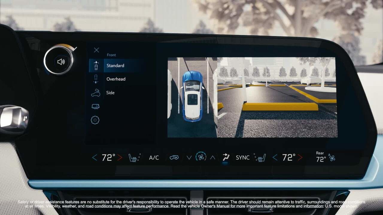 A driver's hands are on the steering wheel of a Chevrolet Equinox EV, looking out through the windshield at a city street. The digital dashboard displays driving information, including a speed indicator, navigation, and other vehicle data. Text at the bottom describes safety and assistance features in French and English.