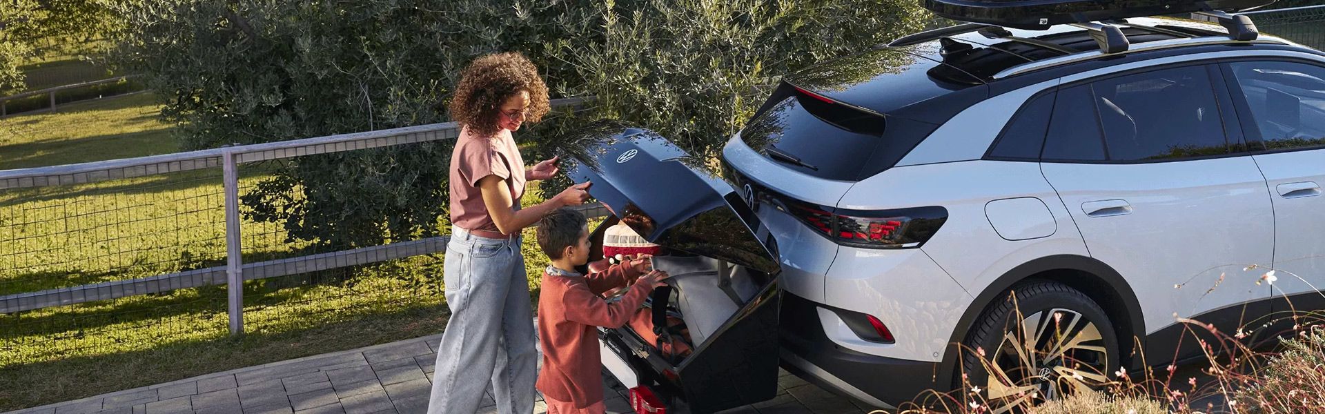 Femme et enfant chargeant un coffre d'attelage.