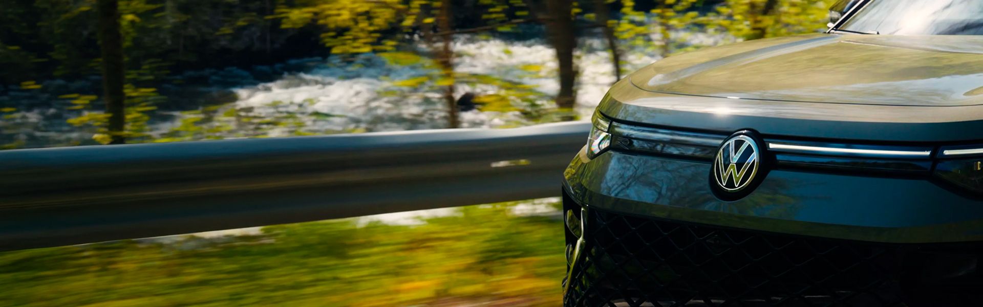 Front view of a Volkswagen driving near a river.