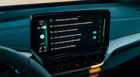 Gros plan sur l'écran tactile du tableau de bord d'une voiture, affichant les réglages des systèmes d'assistance à la conduite (Travel Assist, ACC, Lane Keeping System, etc.).