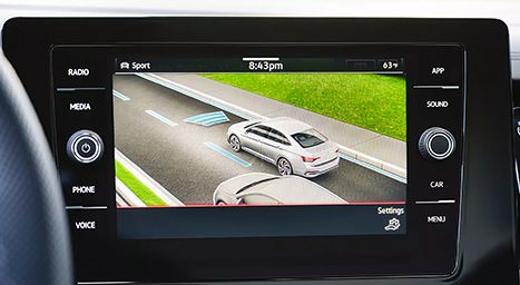 Écran d'infodivertissement affichant l'assistance au maintien de voie et les systèmes de détection de collision, illustrant des voitures sur l'autoroute avec des lignes de détection.