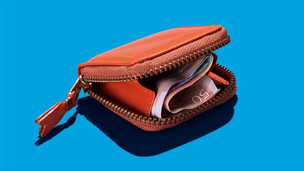An open orange leather zippered wallet filled with Euro banknotes against a bright blue background.