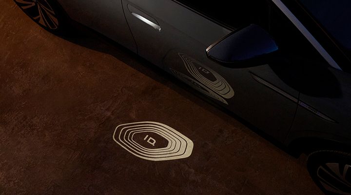 Vue plongeante d'un motif lumineux projeté sur le sol par une voiture la nuit, portant le logo ID.