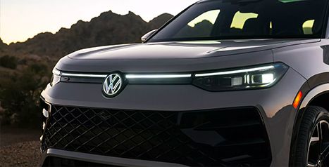 Close-up of the front of a Volkswagen SUV, highlighting the LED headlights, the front light bar, and the new grille design.