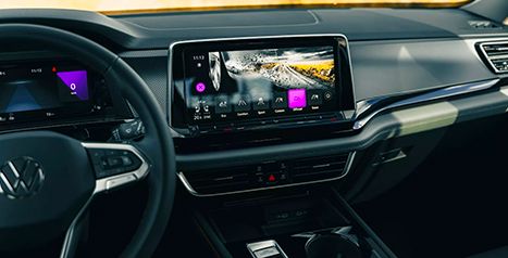 Interior view of a Volkswagen Atlas showing the dashboard and the large central infotainment screen with a drive mode selection menu.