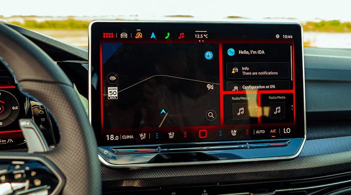 Close-up of a car's large infotainment screen displaying GPS navigation and notifications from the IDA voice assistant.