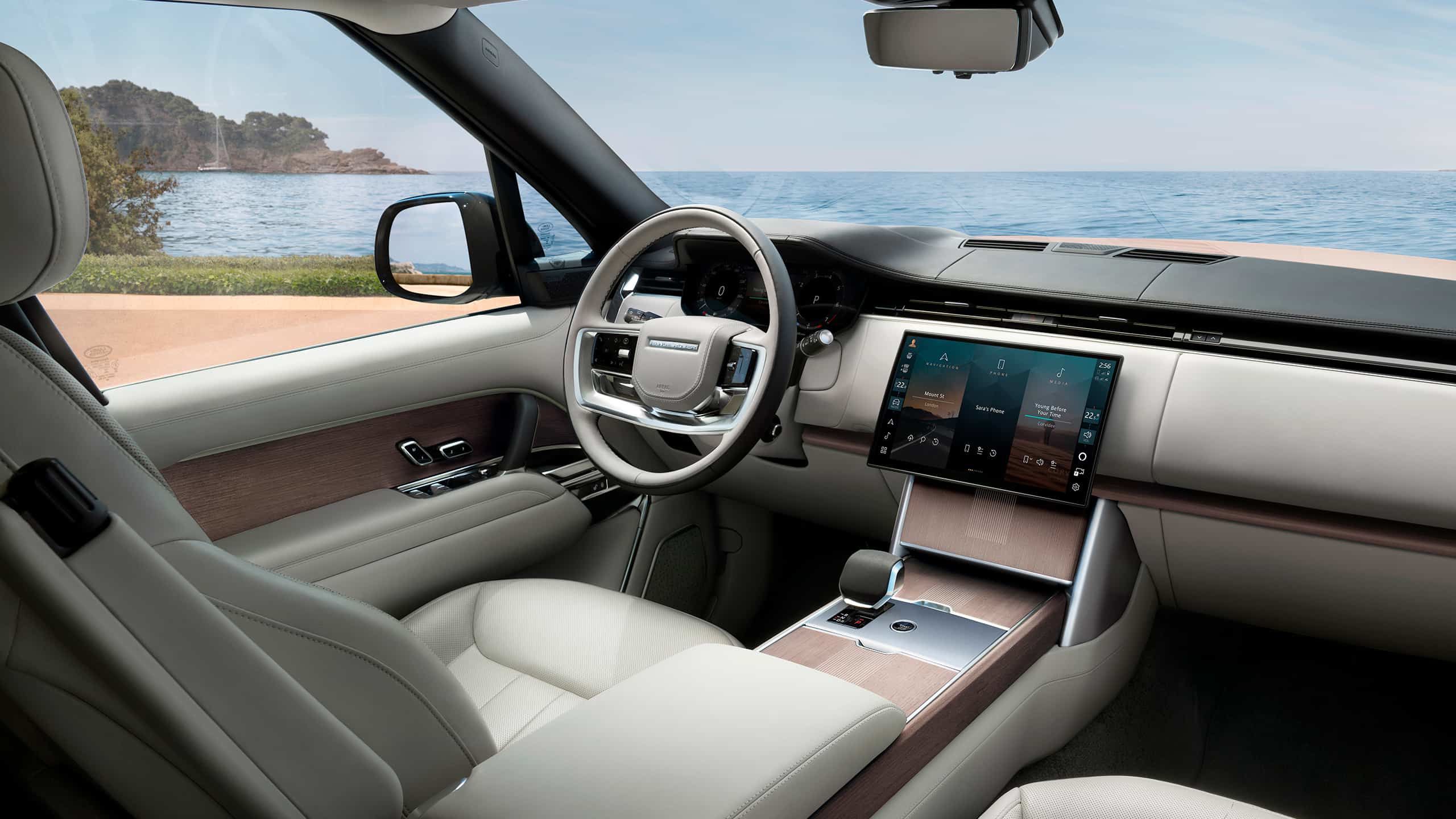 Luxury interior with cream leather seats, wood trim, and a large central screen.