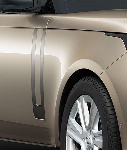 Close-up of the front fender and vertical trim element of a champagne Range Rover.