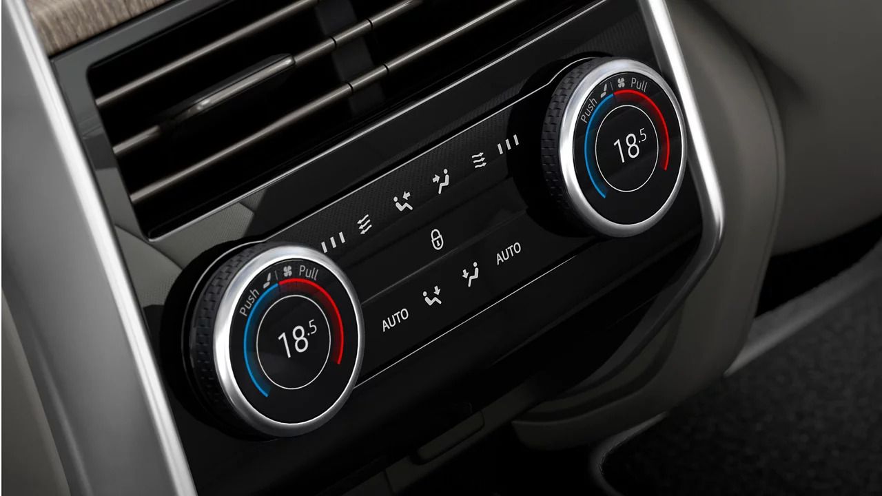 Rear climate control panel with digital dials displaying the temperature.