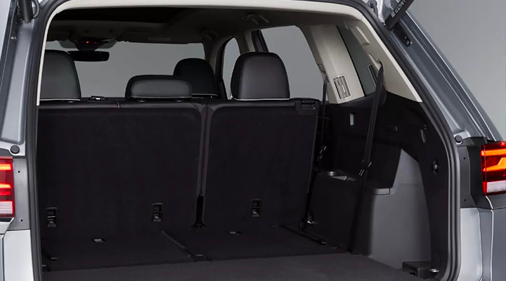 View of the trunk area of a Volkswagen Atlas SUV with the power liftgate open and the third row of seats folded down for maximum cargo space.