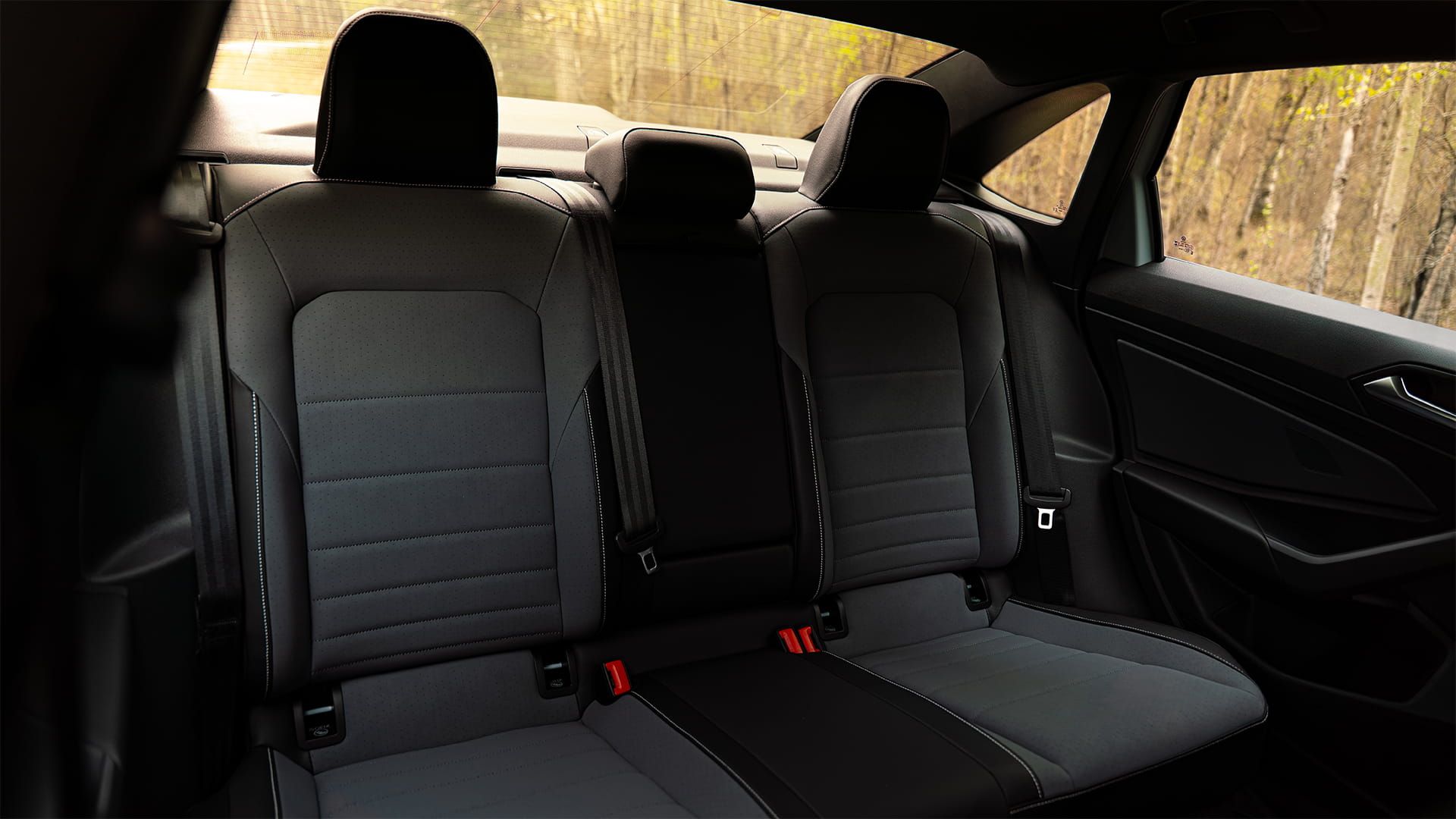 2027 Volkswagen Jetta spacious rear seating with black leatherette upholstery and red seatbelts
