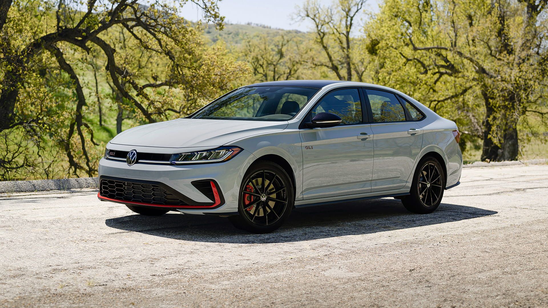 White Jetta GLI parked outdoors, shown in three-quarter view with sporty stance.
