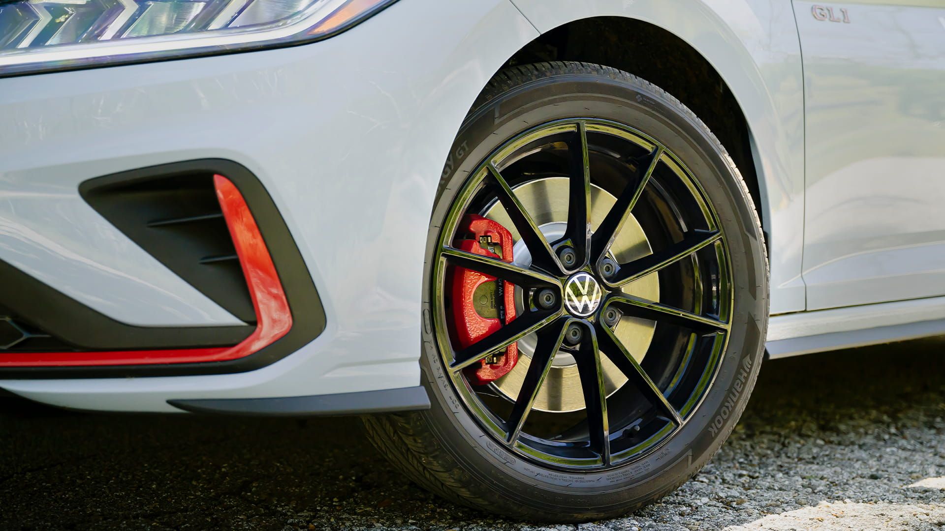 Black alloy wheel on Jetta GLI with red brake caliper and performance tire.