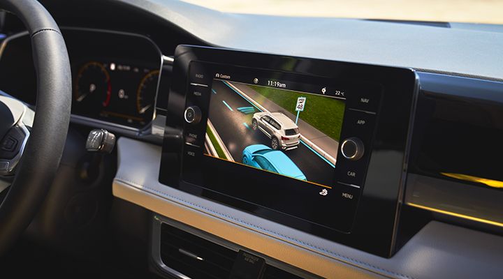 ue intérieure du Taos 2026 de Volkswagen avec écran tactile affichant les fonctions IQ.DRIVEMD et d’aide à la conduite.