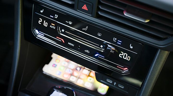 Close-up of the VW Jetta GLI's center console, highlighting the wireless device charging area beneath the climate controls.
