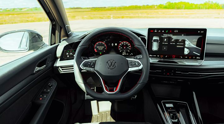 View of the Golf GTI Mk8 driver's cockpit, showing the steering wheel, the digital instrument cluster, and the large central infotainment screen.